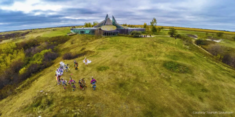 Aerial view of green landscape with traditional dancers in the foreground